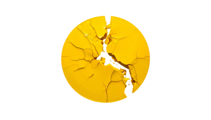 A cracked, bright yellow, circular object against a stark black background