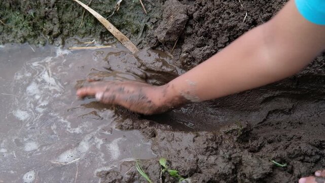 Java, Indonesia, South East Asia: Kid Playing in Muddy Ground Near River