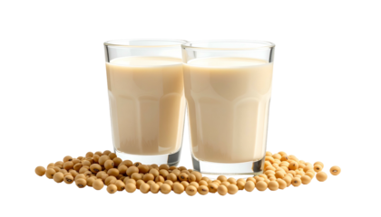 Two glasses of creamy, beige liquid sit with a pile of beige seeds against a black background