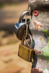 Close-Up of Assorted Padlocks and Chain on Rusted Metal Post