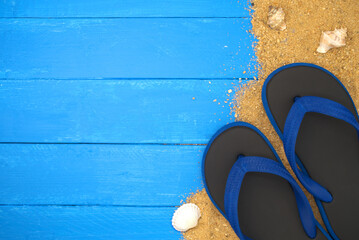 Sandals and sand on blue wooden. Sea summer vacation background with space for the text. Top view