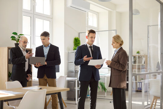 Business team meeting colleagues discussion analysis office. Managers review papers and a laptop, aligning planning and strategy in a modern office. Clear teamwork and leadership concept. - Powered by Adobe