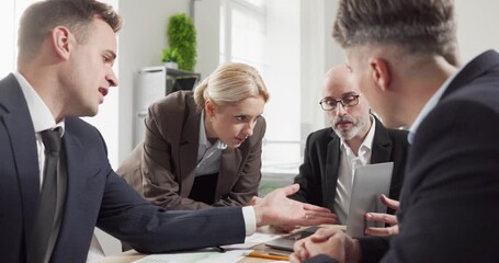 Team executives meeting for strategy collaboration around laptop. Colleagues lead discussion, explain options and seek alignment on project steps in office. Clear teamwork concept for teams. - Powered by Adobe