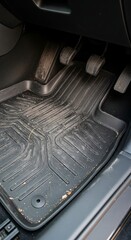 Car interior floor mat with pedals and details.
