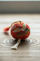 Macro view of a Japanese New Year talisman with crane placed on wood, with gentle lighting creating a calm and symbolic holiday feel.
