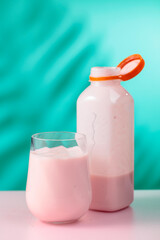 Pink smoothie, vitamin drink, or yogurt on a colorful background.
