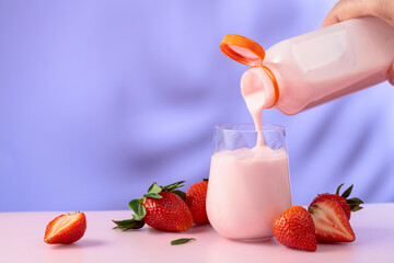 Strawberry milkshake smoothie and fresh berries on a colorful background.