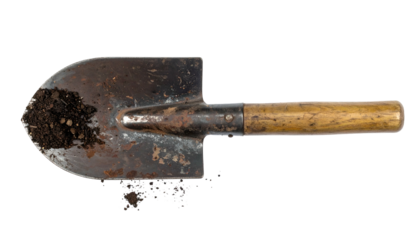 Close-up of a weathered, vintage shovel with earth clinging to the blade