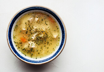 Top-Down Shot of Simple Lemon Pepper Chicken Soup in Stoneware Bowl, Minimal Food Styling, No Garnish