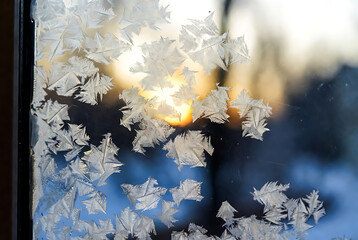 Winter Frost and Snowflakes on Glass with Warm Light Bokeh