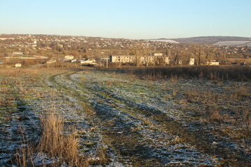 A field with houses and a hill in the background