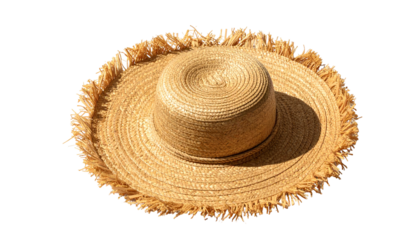 Wide-brimmed straw hat with frayed edges casts a soft shadow on black backdrop