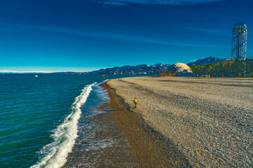 Title: Batumi Pebble Beach with Mountains and Alphabetic Tower
