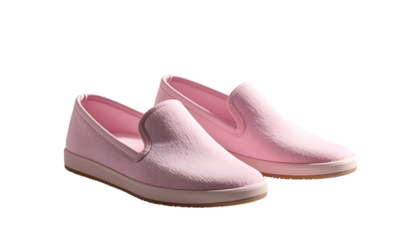 Pair of pastel pink slip-on shoes with light brown soles, isolated on black background
