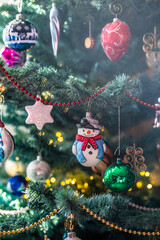 Ein Schneemann als Dekoration an eine Tanne zu Weihnachten