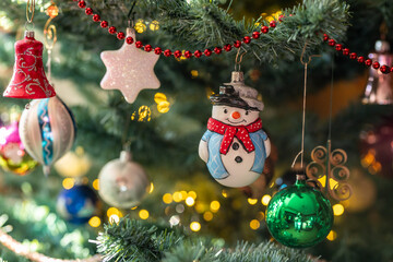 Ein Schneemann als Dekoration an eine Tanne zu Weihnachten