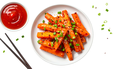 Orange glazed carrot sticks with sesame seeds and green onions, red sauce, chopsticks