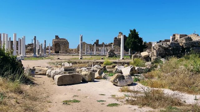 SIDE, TURKEY, June 16, 2024: Ruins of the ancient city of Side in Antalya province on the Mediterranean coast. Amazing ruins of an ancient city. Old statues in the State Agora.The ancient city wall.4K