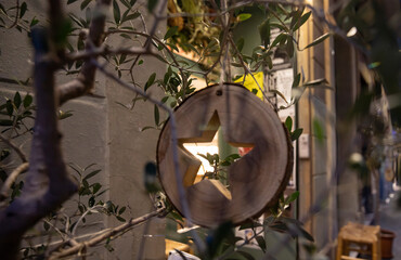 cozy christmas atmosphere with homemade wooden toys in the street. minimalistic star shaped pendant carved from a wooden tree slice