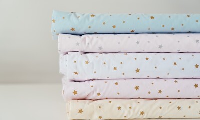 Stack of colorful fabric with golden stars on white background