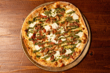 Pizza with sausage and pesto sauce