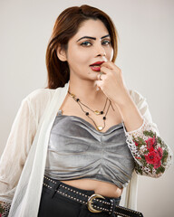 Studio fashion portrait of a confident woman wearing modern clothing and accessories, posing...