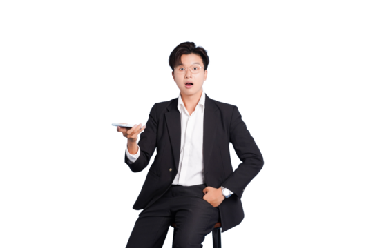 Surprised Businessman with Smartphone: A sharply dressed businessman sits with an open mouth, a look of shocked surprise on his face while holding smartphone. - Powered by Adobe