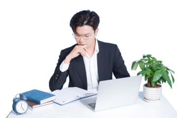 Focused Business: A sharp, professional individual thoughtfully engages in work at a modern workspace, with a laptop, plant, and books, suggesting concentration and ambition.