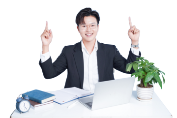 Business Professional's Insight: A confident business professional sits at his desk, with a laptop, books, and potted plant, raising his hands and pointing upwards with a big smile.