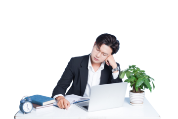 Downtime at Desk: A tired individual rests his head on his hand. Amidst a laptop, notes and clock on his desk, the man appears lost in thought in his working environment.