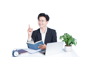 Enlightened Idea: A sharp professional, engrossed in a book, gains an inspiring idea during his work. Expressing deep concentration with laptop and indoor plant