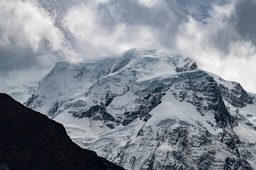 Obraz premium Snow-covered north face of Annapurna II (7,937 meters), photographed from Upper Pisang on the Annapurna Circuit on the way to Manang, Nepal. Dramatic Himalayan mountain landscape with glaciers, rugged