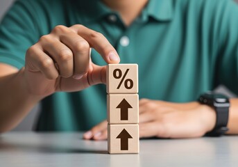 Person stacking wooden blocks with percentage sign and up arrows on a light surface table
