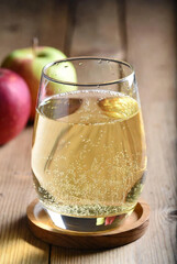 Refreshing Glass of Sparkling Apple Cider on Rustic Wooden Coaster