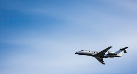 A private jet flying against a clear blue sky.
