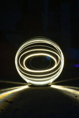 Futuristic Light Painting: Glowing Energy Sphere with Concentric Neon Rings in Darkness
