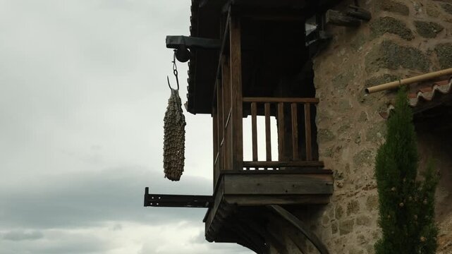 a rope net on a hook near a wooden balcony