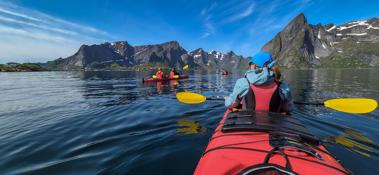 Woman With Kayak On Calm Fjord Near Hamnoy And Reine On Lofoten Islands In Norway