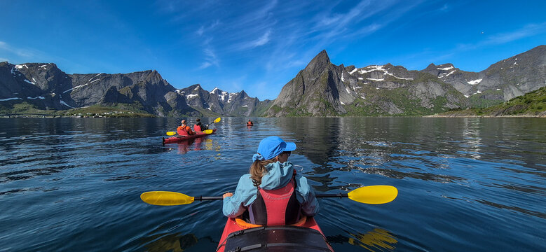 Woman With Kayak On Calm Fjord Near Hamnoy And Reine On Lofoten Islands In Norway