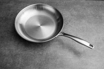 Stainless steel frying pan waiting on a kitchen countertop, ready to be used for cooking, close up