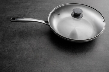 Stainless steel frying pan waiting on a kitchen countertop, ready to be used for cooking, close up
