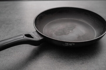 Dirty old non-stick frying pan on grey background