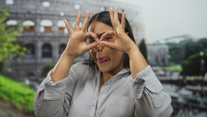 Young woman playfully posing with the roman coliseum in the background, capturing a vibrant moment...