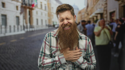 Young caucasian bearded man clutch chest heartattack on urban street amid blurred pedestrians under sunlight; distress.