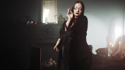 Gothic femme fatale portrait featuring a woman in black godet dress with corseted waist, long straight hair, and dramatic makeup in opulent dimly lit gothic surroundings.