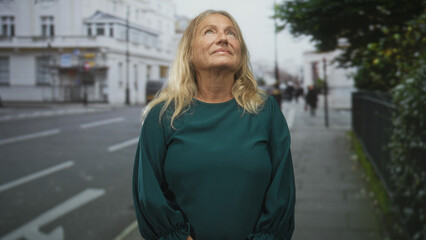Senior woman shows bare neck tilting head back on a street, eyes closed and taking a slow breath...