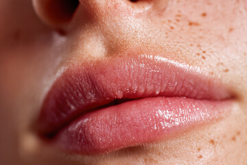 Obraz premium Close-up of soft, glossy lips with a natural look, showcasing a healthy, moisturized appearance and a hint of freckles around the mouth area.