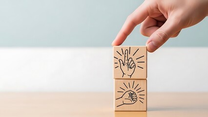 A hand placing wooden blocks with lightbulb and idea drawings on a table with a blue wall in the background