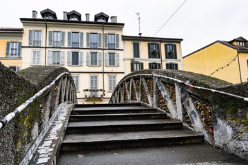 People strolling along Naviglio Grande Canal, in Navigli district full of colorful buildings, cafes and restaurants