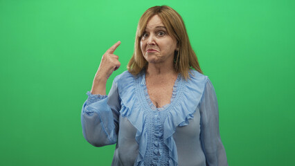Middle age woman with blonde hair and blue blouse showing one two three finger count with raised hand and smirk in studio; playful counting.